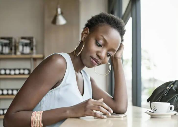 woman looking at phone at table