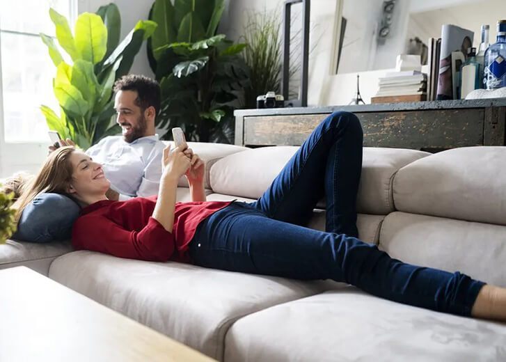 woman laying on man on the couch