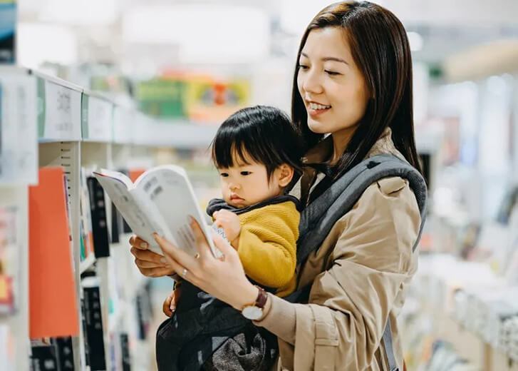 mother with baby looking at book