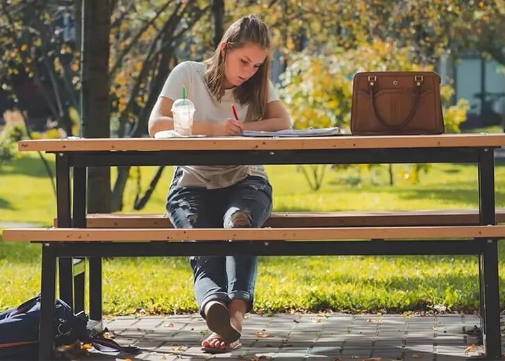 woman at picnic table writing