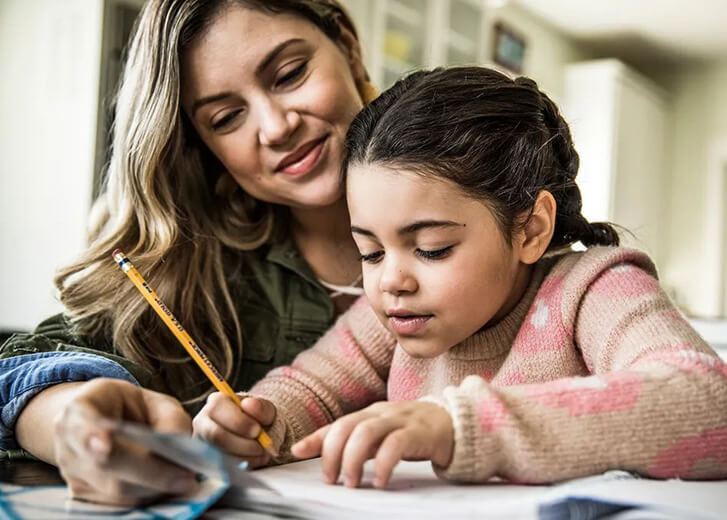woman teaching child to write